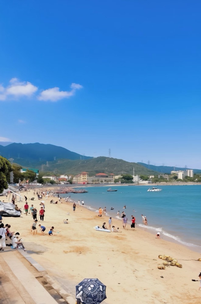 Jiaochangwei beach at Dapeng, with swimmers and umbrellas